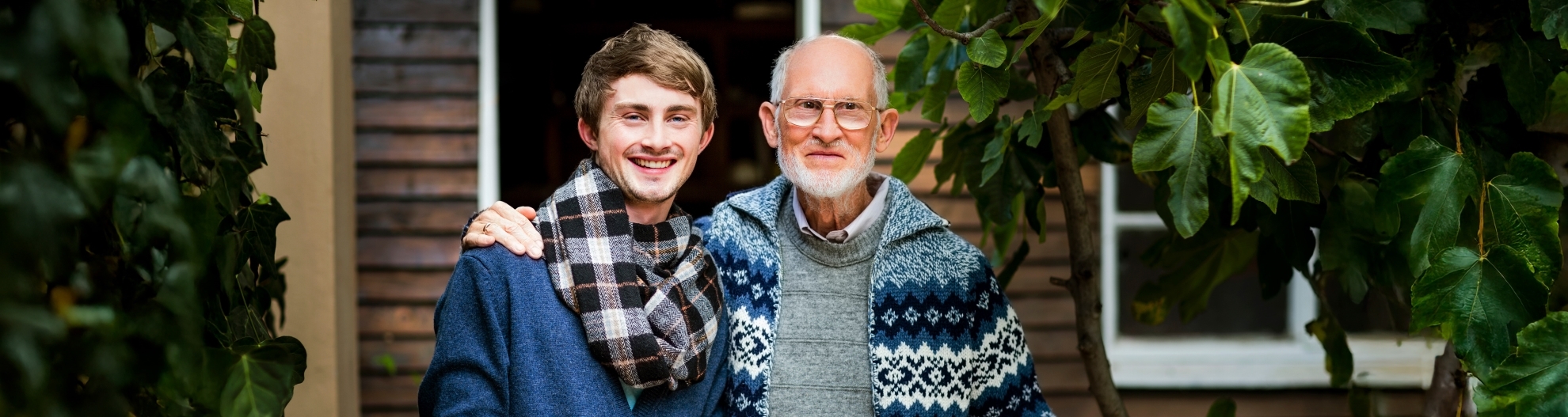 Grandson with grandfather standing in yard