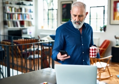 Senior creative professional remote working and checking phone at home